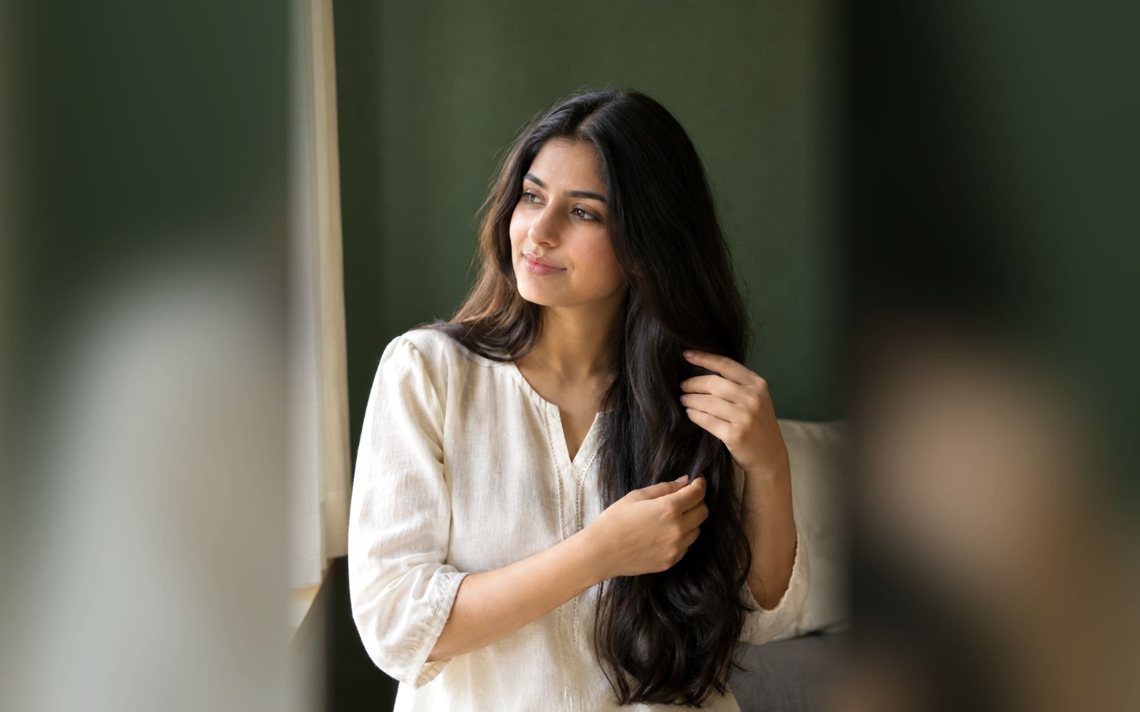 Illustrative hair-care scene of a woman gently handling her dark hair